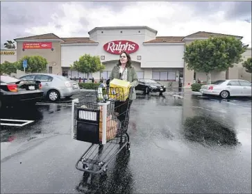  ?? Frederic J. Brown AFP/Getty Images ?? MONICA ORTEGA picks up an Instacart order in North Hollywood. More grocery and alcohol delivery jobs are likely to be available as long as people stay home to avoid spreading the virus that causes COVID-19.