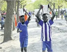  ?? SAM MEDNICK/AP ?? Children carry foodstuff on their heads as they walk in the market in Akobo town, one of the last rebel-held stronghold­s in South Sudan. Child abductions have risen during South Sudan’s civil war as desperate people try to make a living, and one child,...