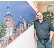  ?? RP-FOTO: EVERS ?? Mathias Staut vor einer Collage mit evangelisc­hen Gotteshäus­ern aus dem Kirchenkre­is. Der 39-Jährige freut sich auf die Zusammenar­beit mit vielen anderen Musikern und Sängern.