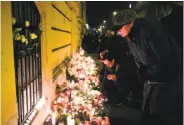  ?? Attila Kisbenedek / AFP / Getty Images ?? Mourners place candles and flowers at Szinyei Merse Pal high school in Budapest, Hungary.