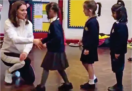  ??  ?? Forget formality: Children queueing to shake Kate’s hand end up hugging and high fiving her instead