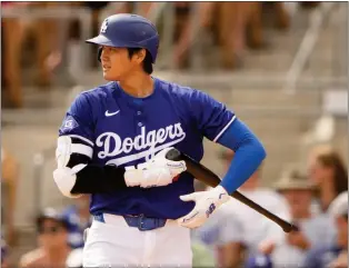  ?? LINDSEY WASSON — THE ASSOCIATED PRESS ?? Los Angeles Dodgers designated hitter Shohei Ohtani adjusts his gloves during an at-bat against the San Francisco Giants during a spring training game.