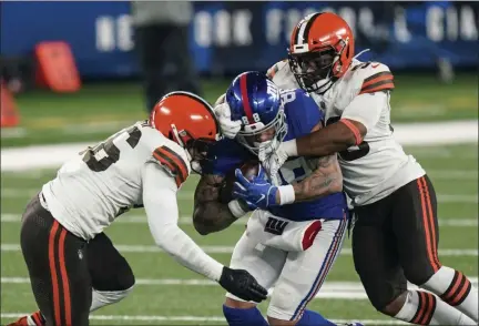  ?? COREY SIPKIN — THE ASSOCIATED PRESS ?? Cleveland Browns’ B.J. Goodson, right, and Malcolm Smith, left, tackle New York Giants’ Evan Engram, center, during the second half of New York’s 20-6loss on Sunday, Dec. 20, in East Rutherford, N.J.