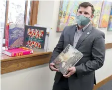  ?? The Sentinel-Record/Richard Rasmussen ?? Q Garland County Library Executive Director Adam Webb stands by some of the art books donated by the Alice L. Walton Foundation, Crystal Bridges Museum of American Art and the Arkansas State Library on Tuesday.