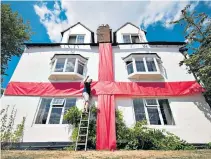  ??  ?? National pride: While once the country was indifferen­t about the tournament, now houses – such as this one in in Ashbourne, Derbyshire – are being draped in the flag of St George