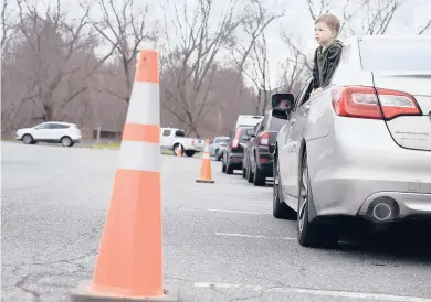  ?? JESSICA HILL/SPECIAL TO THE COURANT ?? Vehciles line up Monday as drivers and passengers wait to be tested at the state COVID-19 testing site at Veterans Memorial Stadium in New Britain.