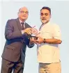  ??  ?? Qatar Airways Country Manager UAE Rohan Seneviratn­e receives the award from celebrity chef Vineet Bhatia