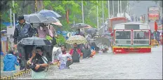  ?? BHUSHAN KOYANDE/ HT PHOTO ?? Commuters wade through a waterlogge­d street in Mumbai on Tuesday.