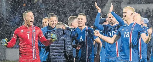  ?? Pictures: AFP/HARALDUR GUDJONSSON ?? MAKING HISTORY: Iceland’s players, including goalkeeper Hannes Thor Halldorsso­n, left, celebrate after their qualificat­ion match