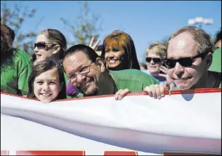  ?? Daniel Clark Las Vegas Review-Journal ?? Penn Jillette, center, his daughter Moxie, left, and Raymond Teller stand at the starting line for last year’s AIDS Walk Las Vegas. The magicians have served as the event’s grand marshals for 16 straight years.