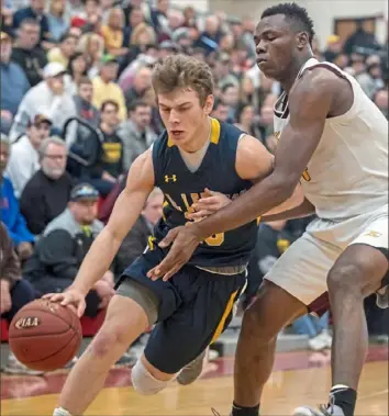  ?? Alexandra Wimley/Post-Gazette ?? Mt. Lebanon’s Mike Palmer, left, drives past Kennedy Catholic’s Oscar Tshiebwe in a Class 6A quarterfin­al game Saturday at Aliquippa High School. With Tshiebwe scoring 25 points, the Eagles defeated Mt. Lebanon, 68-51.