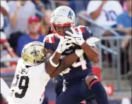  ?? Elsa / Getty Images ?? The Patriots’ Kendrick Bourne (84) makes the catch and runs it in for a touchdown as the Saints’ Paulson Adebo defends in the fourth quarter on Sunday in Foxborough, Mass.