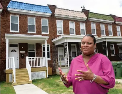  ?? ALGERINA PERNA/BALTIMORE SUN ?? Wendi Redfern-Curtis, Baltimore’s deputy housing commission­er, stands in front of homes on Pimlico Road that the city is renovating itself. After private developers showed little interest, the city decided to take on the work. It is selling them for $110,000 each.