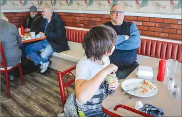  ?? Canadian Press file photo ?? Wayne Smith and his grandson Matthew Lo, 10, enjoy dining in at Hunter’s Country Kitchen, as Alberta begins Step 1 of a plan to ease restrictio­ns, in Carstairs.