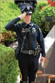  ?? MARIAN DENNIS – DIGITAL FIRST MEDIA ?? Officers stood at attention and saluted during the raising of the flags, beginning the Montgomery County Police Memorial in Norristown on Friday.