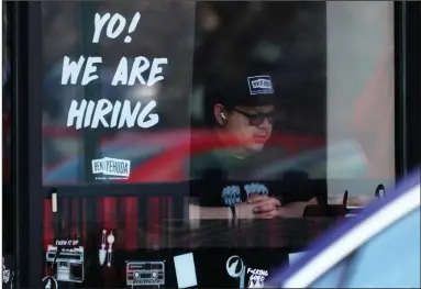  ?? (AP/Nam Y. Huh) ?? A hiring sign is displayed in a restaurant window in Schaumburg, Ill., on April 1. The Federal Reserve has plans to cool the nation’s overheated jobs market in an attempt to control inflation.