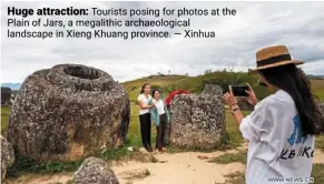  ?? — Xinhua ?? Huge attraction: Tourists posing for photos at the Plain of Jars, a megalithic archaeolog­ical landscape in Xieng Khuang province.