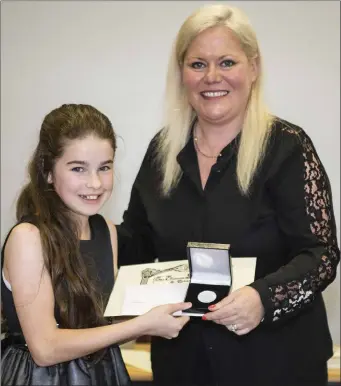  ??  ?? Clodagh Barrett receiving her certificat­e and silver medal from Karen Casey, Head of the Leinster School of Music and Drama.