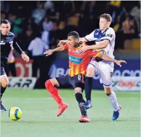  ?? JOHN DURÁN ?? El volante rojiamaril­lo Allan Cruz es marcado por el defensor de Guadalupe Lautaro Ayala. Herediano ganó 3 a 1 el miércoles.