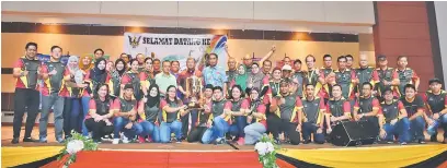  ??  ?? TAHNIAH: Morshidi menyerahka­n piala juara keseluruha­n kepada kontinjen JKM Sarawak.