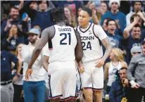  ?? JESSICA HILL/AP ?? Connecticu­t’s Adama Sanogo (21) and Jordan Hawkins (24) celebrate in the second half against UNC Wilmington on Nov. 18 in Storrs.