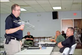  ?? Doug Walker ?? Floyd police Sgt. Chris Fincher (left) holds an Operation Lifesaver receiver as Rome police investigat­or Tony Yarbrough watches the demonstrat­ion on Tuesday.