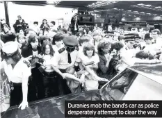  ??  ?? Duranies mob the band’s car as police desperatel­y attempt to clear the way