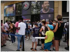  ?? (AP/Francois Mori) ?? People line up outside the official PSG shop at the Parc des Princes stadium in Paris on Wednesday to buy a jersey bearing the name of Lionel Messi. The wait is on for Messi’s debut with his new French team, and he is expected to be present before kickoff of Saturday’s game against Strasbourg.