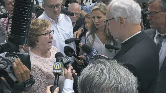  ?? Darrell Sapp/Post-Gazette ?? Judy Jones, Midwest regional leader of the Survivors Network of those Abused by Priests, or SNAP, talks with the Rev. Ronald Lengwin outside Diocese of Pittsburgh headquarte­rs on Monday in Downtown. SNAP is fighting to give abuse victims more time to come forward in court.