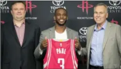  ?? THE ASSOCIATED PRESS ?? Chris Paul, center, holds his new jersey as he is joined by Houston Rockets general manager Daryl Morey, left, and coach Mike D’Antoni, right, during a news conference Friday.