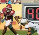  ?? O’MEARA/AP CHRIS ?? Arkansas quarterbac­k KJ Jefferson (1) slips a tackle by Penn State safety Jaylen Reed en route to a 24-10 win in the Outback Bowl in Tampa on New Year’s Day.