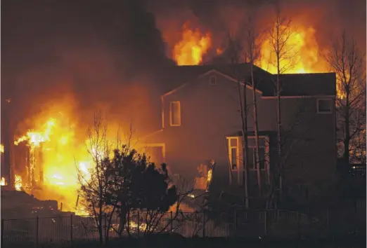  ?? DAVID ZALUBOWSKI/AP ?? Homes burn as wildfires rip through a developmen­t Dec. 30 in Superior, Colo.