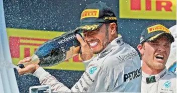  ??  ?? Mercedes driver Lewis Hamilton (left) of Britain sprays champagne on the podium to celebrate his victory in the Hungary Formula One Grand Prix at the Hungarorin­g racetrack in Budapest on Sunday.