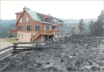  ?? George Frey Getty Images ?? THE WILDFIRE that began June 17 burned up to the edge of this home near Panguitch, Utah. A state politician blamed environmen­talists for conditions that led to the fire, a charge that was denounced as “shameful.”