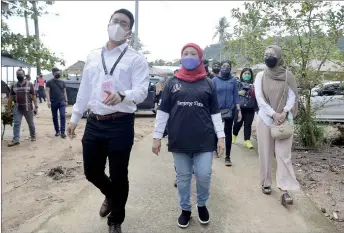  ?? — Bernama photo ?? Nancy with Azizul during a walkabout in Telok Melano.