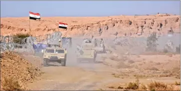  ??  ?? Iraqi forces gather near the al-Qaim border crossing between Syria and Iraq. — AFP photo