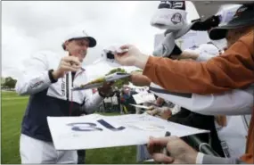  ?? DAVID J. PHILLIP — THE ASSOCIATED PRESS ?? Phil Mickelson signs autographs during a practice round for the Ryder Cup at Hazeltine National Golf Club in Chaska, Minn. on Wednesday.