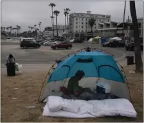  ?? JAE C. HONG — THE ASSOCIATED PRESS ?? Jose Formoso, who said he moved from Malibu in 2021, sits in his tent near the boardwalk in the Venice neighborho­od of Los Angeles.