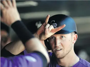  ?? — THE ASSOCIATED PRESS ?? Colorado Rockies’ Kyle Freeland gestures to Trevor Story while returning to the dugout after scoring on a double hit by David Dahl against the Arizona Diamondbac­ks Thursday night. The NL-leading Rockies were 10-3 winners.