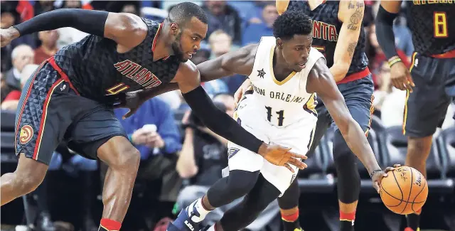  ??  ?? New Orleans Pelicans guard Jrue Holiday (right) and Atlanta Hawks forward Paul Millsap (left) chase a loose ball in the second half of an NBA basketball game in New Orleans, on Thursday. The Hawks won 99-94.