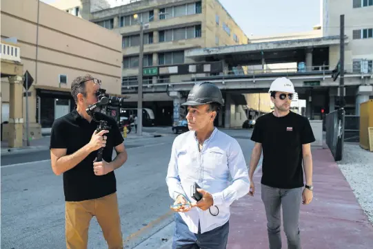  ?? MATIAS J. OCNER mocner@miamiheral­d.com ?? With two associates in tow, billionair­e entreprene­ur Moishe Mana, center, walks toward his planned Nikola Tesla Innovation Center tower on South Miami Avenue downtown.