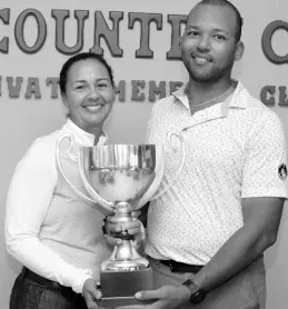  ?? ?? President of the Jamaica Golf Associatio­n Jodi Munn Barrow (left) presents the National Amateur Golf Championsh­ip trophy to William Knibbs.