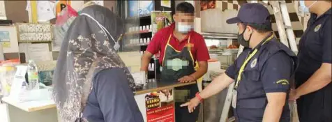  ?? ?? PENGUAT KUASA Jawi menjalanka­n pemantauan di sebuah restoran di sekitar ibu kota yang menempatka­n tabung derma.