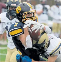  ?? JULIA MALAKIE / SENTINEL & ENTERPRISE ?? Littleton’s Max Hannagan is hit by St. Bernard’s Antonio Mancini during Thursday’s game.