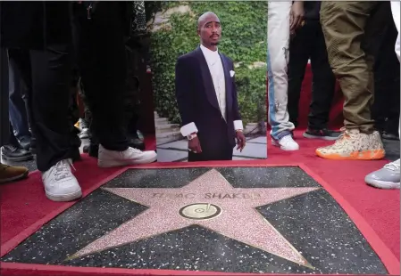  ?? CHRIS PIZZELLO — THE ASSOCIATED PRESS ?? An image of Tupac Shakur appears near his new star on the Hollywood Walk of Fame during a posthumous ceremony Wednesday in Los Angeles.
