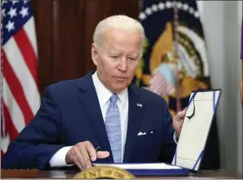  ?? PABLO MARTINEZ MONSIVAIS — THE ASSOCIATED PRESS ?? President Joe Biden signs into law the gun violence bill in the Roosevelt Room of the White House in Washington on Saturday.
