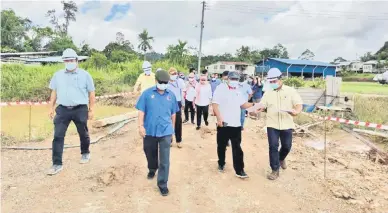  ?? — Gambar JKR Opis Kandang Menua Tengah ?? NGELAWA KEDIRI: Aaron (dua kanan), Rolland (dua kiba) sereta bala bukai lebuh ti ngelawa ke Projek Perambu Nembuka Laluh Kereja Ungkup Klinik Pengerai (Bansa 6) Enggau Kuarters di Nanga Kemalih, Ulu Entabai, Julau, kemari.