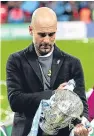  ??  ?? Pep Guardiola with his first trophy since taking over the reins at the Etihad Stadium.