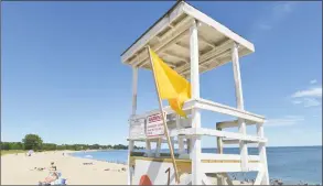  ?? Alex von Kleydorff / Hearst Connecticu­t Media ?? A yellow flag on the lifeguard stand means no lifeguard on duty at Sherwood Island State Park on Tuesday in Westport. The park is currently short staffed and needs more lifeguards to open the three stands along the beach.