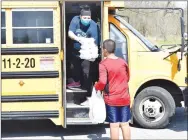  ?? Westside Eagle Observer/MIKE ECKELS ?? Desirea Montano hands breakfast and lunch boxes to a Decatur Middle School student April 2 during the district’s free lunch program distributi­on near the Grant Springs Apartments in Decatur.